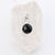 Small onyx circle pendant encased in sterling silver dangling from a sterling silver beaded stretch bracelet and displayed on white background