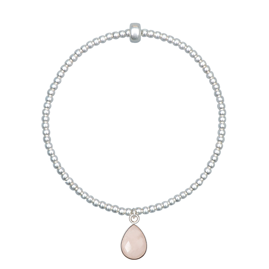 Dainty sterling silver beaded stretch bracelet featuring a natural rose quartz teardrop charm encased in sterling silver