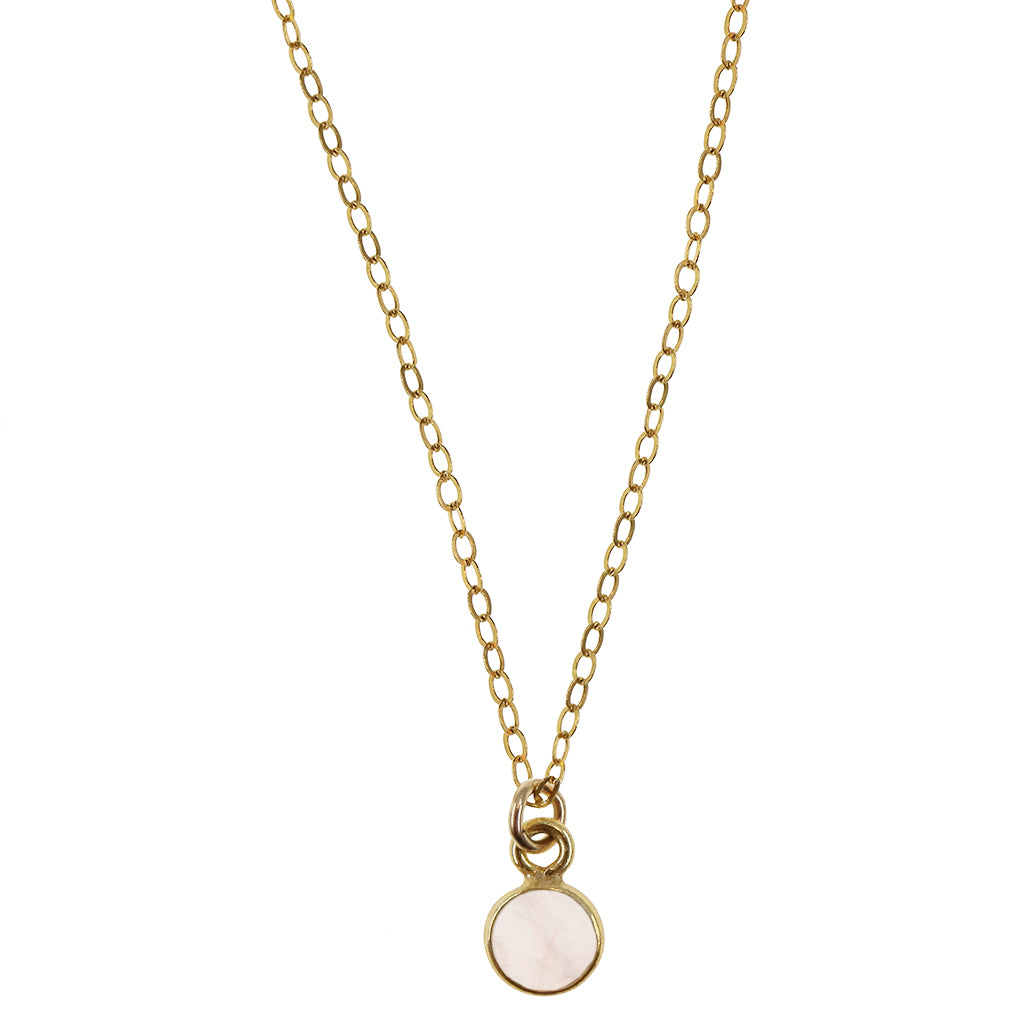 rose quartz circle pendant encased in gold strung on gold cable chain